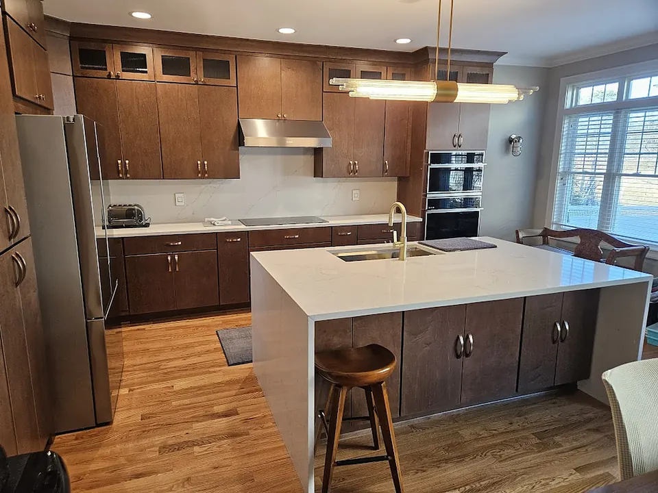 Walnut kitchen cabinets with white waterfall quartz island