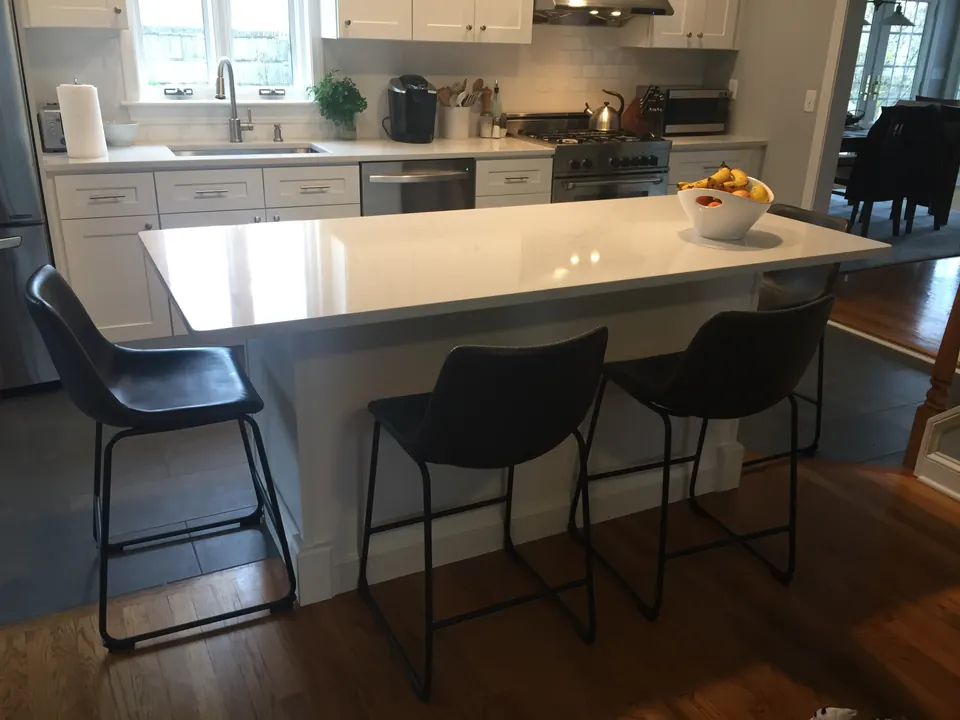 White quartz island with leather bar stools